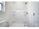 Bathroom features a stand up shower with built-in shelving and toilet with window at 66 Reed Ne St, Concord, NC 28025