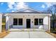 Charming home featuring a covered porch, black-framed windows, and freshly painted white siding at 66 Reed Ne St, Concord, NC 28025