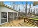 Wooden back deck with stairs and a screened-in porch showcasing an outdoor dining area and grill at 7224 St Clair Dr, Charlotte, NC 28270