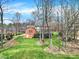 View of house from backyard featuring lush green grass and mature trees at 7224 St Clair Dr, Charlotte, NC 28270