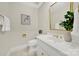 Elegant powder room featuring a white vanity, decorative mirror, stylish gold fixtures, and botanical accents at 7224 St Clair Dr, Charlotte, NC 28270