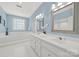 Bright bathroom featuring double vanity sinks, decorative mirrors, and a soaking tub at 7224 St Clair Dr, Charlotte, NC 28270