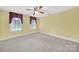 Bright bedroom with carpet floors, a ceiling fan, and two windows at 7224 St Clair Dr, Charlotte, NC 28270
