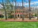 Charming two-story brick home with manicured lawn and mature trees creating privacy at 7224 St Clair Dr, Charlotte, NC 28270