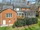 Brick home exterior showcasing a deck, screened porch, and lush landscaping, blending indoor/outdoor living at 7224 St Clair Dr, Charlotte, NC 28270