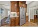 Kitchen area showcasing stainless steel refrigerator and wooden cabinetry with modern finishes at 7224 St Clair Dr, Charlotte, NC 28270