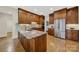 Well-equipped kitchen featuring stainless steel refrigerator, granite counters, and wooden cabinets at 7224 St Clair Dr, Charlotte, NC 28270