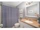 Modern bathroom with a white vanity, blue shower curtain, and blue walls at 7300 Falkirk Pl, Charlotte, NC 28270