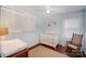 Bedroom featuring hardwood floors, baby crib, rocking chair, and a changing table at 7300 Falkirk Pl, Charlotte, NC 28270