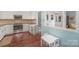 Open concept kitchen featuring white cabinets, mosaic backsplash, stainless steel appliances, and a small table at 7300 Falkirk Pl, Charlotte, NC 28270