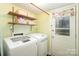 Laundry room featuring modern washer and dryer with shelves, a door to the back at 7300 Falkirk Pl, Charlotte, NC 28270