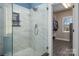 Bathroom featuring a marble-tiled shower, glass door and walk-in closet at 8018 Cotton St, Harrisburg, NC 28075