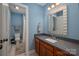 Light blue bathroom features modern vanity with a gray countertop and shower/tub at 8018 Cotton St, Harrisburg, NC 28075