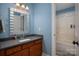Light blue bathroom features modern vanity with a gray countertop and shower/tub at 8018 Cotton St, Harrisburg, NC 28075