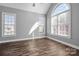 Spacious bedroom featuring hardwood floors, high ceilings, and ample natural light from two windows at 8018 Cotton St, Harrisburg, NC 28075