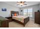 Bedroom with wooden bed frame, window, ceiling fan and neutral colored walls at 8018 Cotton St, Harrisburg, NC 28075