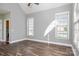 Bright bedroom with hardwood floors, two windows, and neutral paint, creating a cozy atmosphere at 8018 Cotton St, Harrisburg, NC 28075