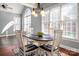 Bright dining area with large windows, hardwood floors, and stylish chandelier above a circular table at 8018 Cotton St, Harrisburg, NC 28075