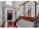 Bright foyer boasts wood floors, staircase with white railing, and arched entry door with sidelights at 8018 Cotton St, Harrisburg, NC 28075