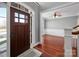 Light-filled foyer features wood floors, an entry door with sidelights, and view of formal living room at 8018 Cotton St, Harrisburg, NC 28075