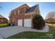 This two car garage has an ample driveway and a small green lawn at 8018 Cotton St, Harrisburg, NC 28075