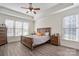 Well-lit main bedroom featuring tray ceilings, hardwood floors, and a large window at 8018 Cotton St, Harrisburg, NC 28075