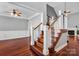 Spacious staircase with wood treads, white risers, and iron balusters connecting the living areas at 8018 Cotton St, Harrisburg, NC 28075
