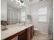 Bathroom features a light countertop, tiled floor, and tub-shower with a neutral-toned shower curtain at 809 Circle Trace Rd, Monroe, NC 28110