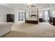 Large main bedroom with tray ceiling, neutral carpet, canopy bed and ample closet space at 809 Circle Trace Rd, Monroe, NC 28110