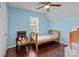 Light blue bedroom featuring a single bed, overhead fan and charming decor at 8721 Brampton Dr, Charlotte, NC 28215