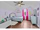 bedroom is painted purple and features wood floors, a fan, and large dresser at 8721 Brampton Dr, Charlotte, NC 28215