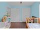 Bright blue bedroom with two closets, wood floors, ceiling fan, and bed at 8721 Brampton Dr, Charlotte, NC 28215