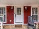 Inviting front door with charming decor, framed by red brick and classic exterior lighting at 8721 Brampton Dr, Charlotte, NC 28215