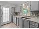 Bright kitchen features stainless steel appliances, quartz countertops, and backyard views from the window at 8721 Brampton Dr, Charlotte, NC 28215