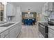 Contemporary kitchen features gray cabinetry, stylish backsplash, and open layout to dining area at 8721 Brampton Dr, Charlotte, NC 28215