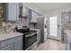 Updated kitchen features sleek gray cabinets, stainless steel appliances, and stylish tile backsplash at 8721 Brampton Dr, Charlotte, NC 28215