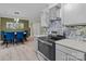 Modern kitchen with sleek appliances, gray cabinets, and an adjacent dining area at 8721 Brampton Dr, Charlotte, NC 28215