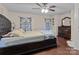 Cozy main bedroom boasts wood floors, ample lighting, decorative curtains, and a dresser at 8721 Brampton Dr, Charlotte, NC 28215