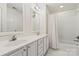 Bright bathroom featuring double sink vanity, tub with shower, and white tile at 9036 Saint Thomas Ln, Charlotte, NC 28277