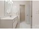 Bright bathroom featuring white cabinets, a white marble countertop, and white ceramic tile flooring at 9036 Saint Thomas Ln, Charlotte, NC 28277