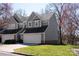 Charming gray two-story townhouse featuring an attached two car garage and well-manicured lawn at 9036 Saint Thomas Ln, Charlotte, NC 28277