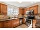 Well-equipped kitchen with stainless steel appliances and warm wood cabinetry at 9036 Saint Thomas Ln, Charlotte, NC 28277