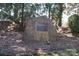 Entrance sign to the private Raintree Country Club on a stone surrounded by trees and mulch at 9036 Saint Thomas Ln, Charlotte, NC 28277