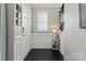 Bright foyer with elegant wainscoting, a charming decorative shelf, and dark hardwood flooring at 919 Pennington Dr, Indian Land, SC 29720