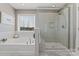 Well-lit bathroom with a soaking tub, a walk-in shower, and a window at 919 Pennington Dr, Indian Land, SC 29720