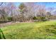 A large backyard featuring a lush green lawn with a fence and mature trees at 10436 Cullen Ct, Charlotte, NC 28278