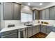 Stylish kitchen features gray cabinetry, white subway tile backsplash and stainless steel dishwasher at 10436 Cullen Ct, Charlotte, NC 28278