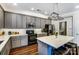 Modern kitchen featuring gray cabinets, black appliances and a kitchen island with seating at 10436 Cullen Ct, Charlotte, NC 28278
