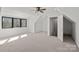 Bright, carpeted attic space with dormers, ceiling fan, and closet with white door at 106 Beachview Dr, Mooresville, NC 28117