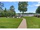 Lush backyard featuring a pool, patio, and a pathway, leading to a lake and dock at 106 Beachview Dr, Mooresville, NC 28117